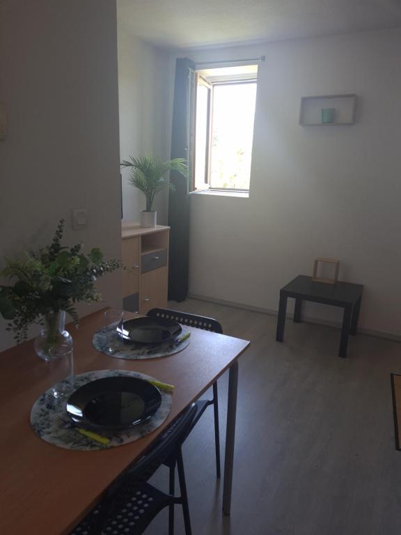 une pièce avec une table, des chaises et une fenêtre dans l'établissement Le Zénith, à Sotteville-lès-Rouen