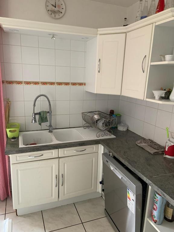 une cuisine avec des armoires blanches et un évier dans l'établissement les amandiers, à Salses-le-Chateau