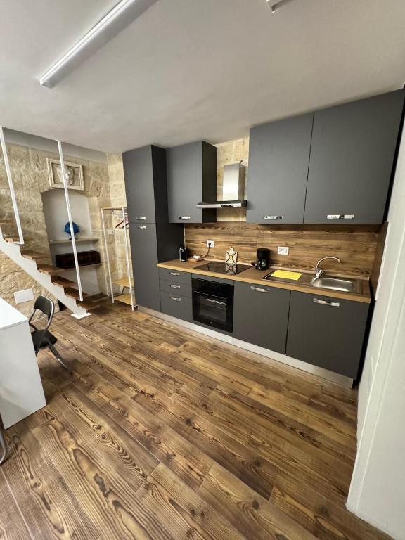 a kitchen with wooden floors and stainless steel appliances at Quarata Apartment Corato mini appartamento in Corato