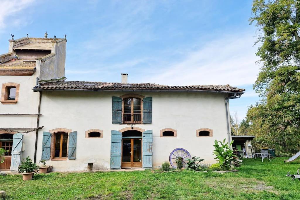 une vieille maison blanche avec des fenêtres à volets bleus dans l'établissement Charmante Maison campagne Tarn, à Loupiac