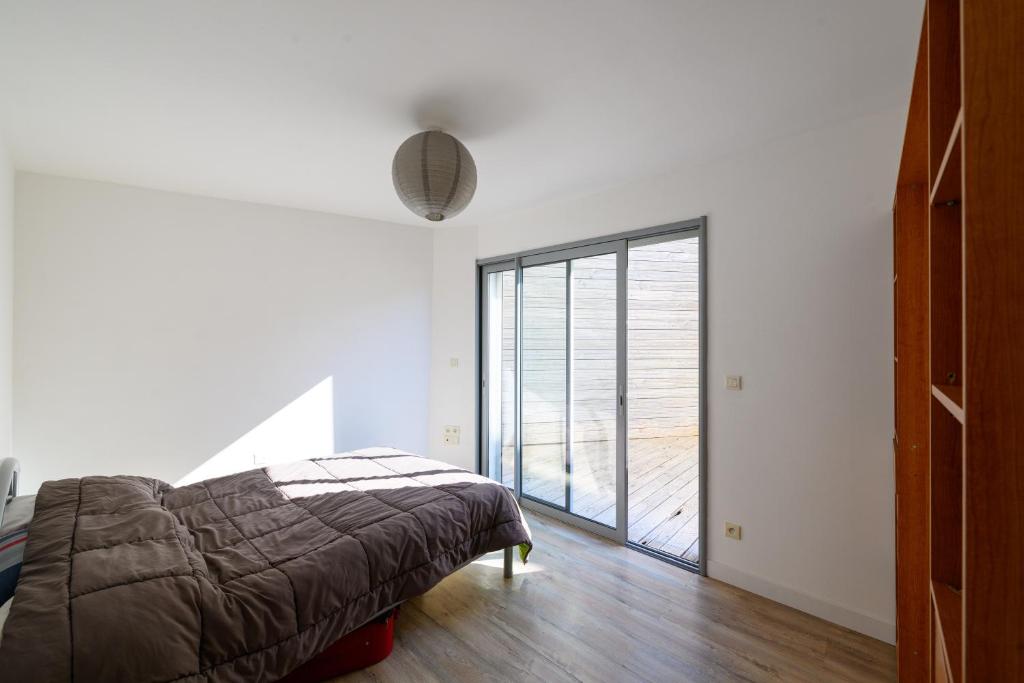 une chambre avec un lit et une grande fenêtre dans l'établissement Les deux mers, à Sainte-Maxime