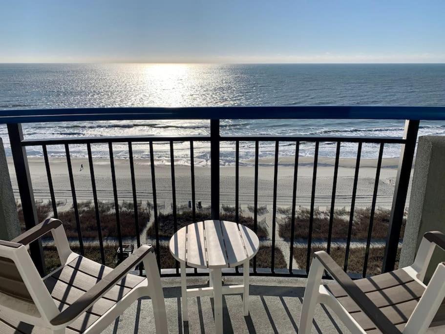 a balcony with chairs and a table and the beach at Endless Ocean View Beachfront 1131 in Myrtle Beach