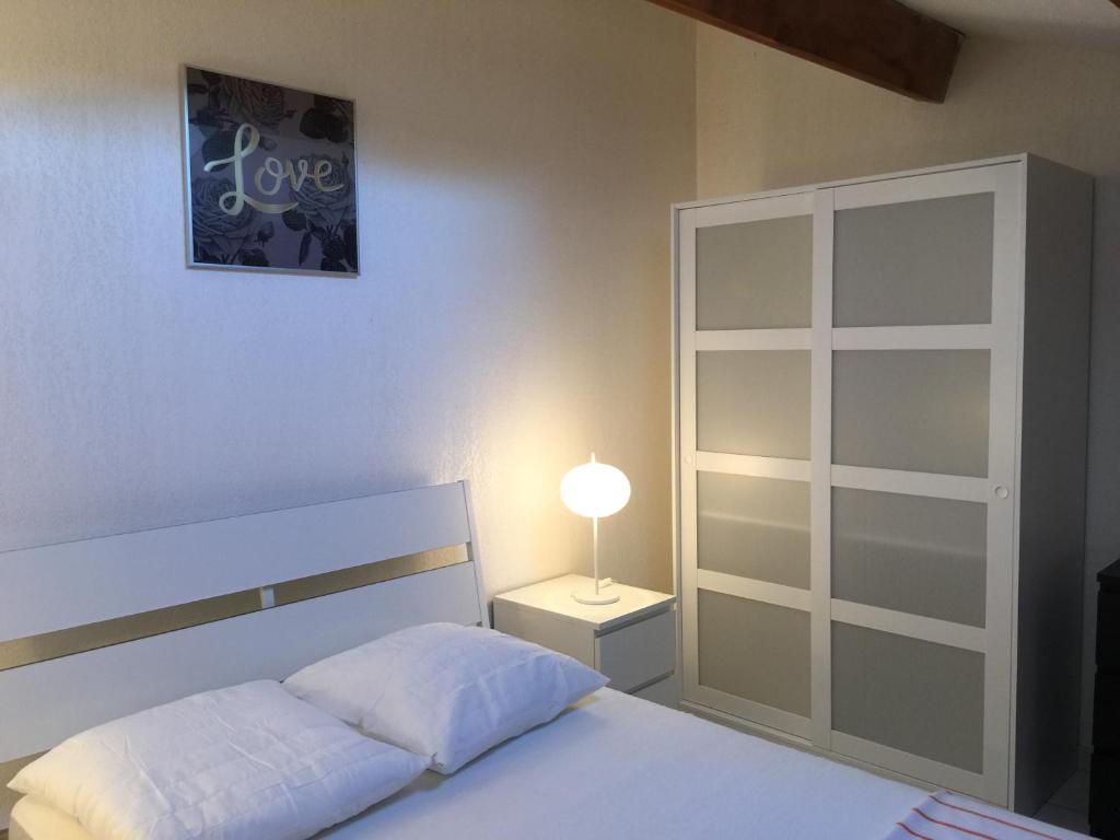 a bedroom with a bed and a lamp on a night stand at Residence Enzo Paradise in La Seyne-sur-Mer