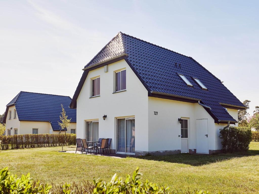 una casa bianca con tetto blu di Ferienhaus im Van der Valk Resort in Linstow a Dobbin-Linstow