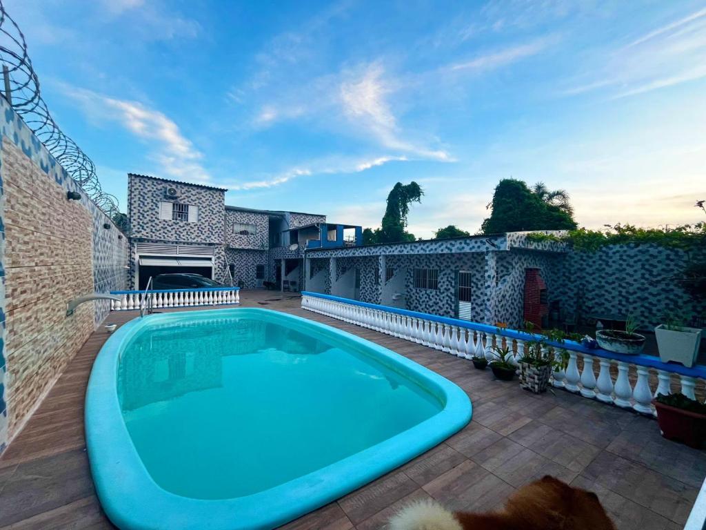 Una gran piscina en un patio con una casa. en Pousada da Ildi, en Itanhaém