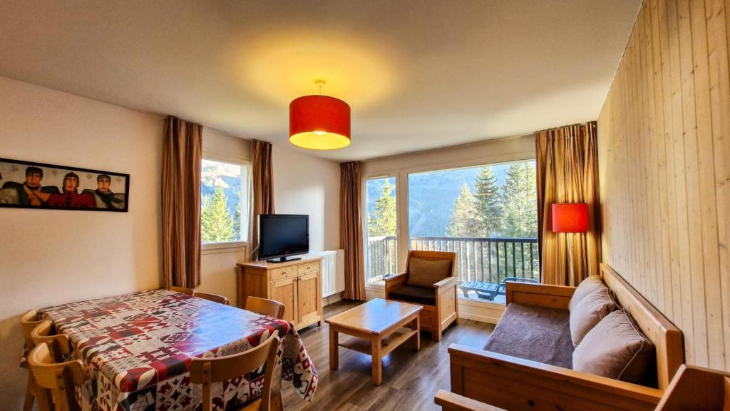 a bedroom with a bed and a television and a balcony at Résidence Les Pleiades - Appartement spacieux et lumineux · Centre station · Balcon · Parking couvert MAE-7354 in Flaine