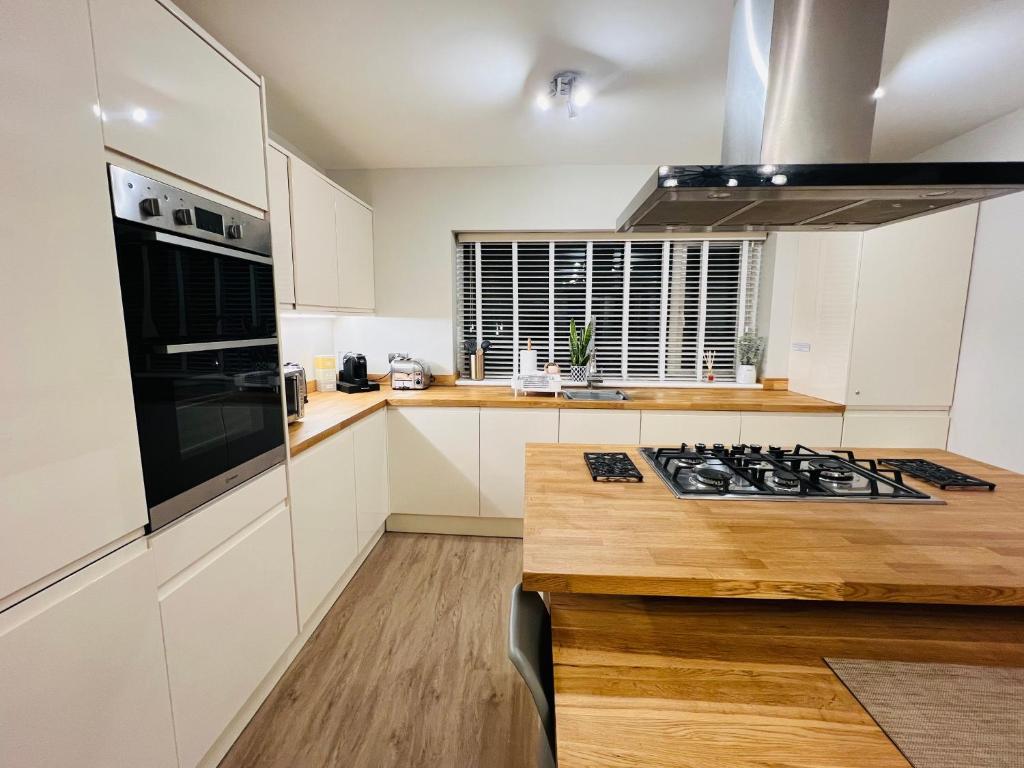 a kitchen with white cabinets and a stove top oven at The Duplex Margate with Deck & Living Space Air Conditioning in Margate