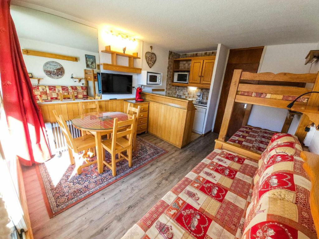 Cette chambre comprend une cuisine et une table avec un lit. dans l'établissement Résidence Tougnette - Studio équipé au pied des pistes avec vue panoramique MAE-3994, aux Menuires