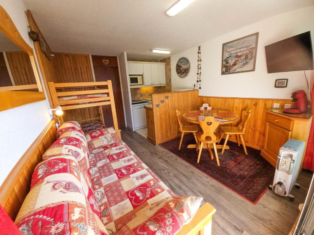 Cette chambre comprend un lit, une table et une cuisine. dans l'établissement Résidence Cherferie - Appartement sur les pistes au coeur des Menuires avec vue panoramique MAE-3974, aux Menuires