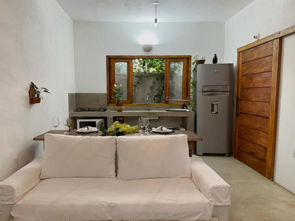 un soggiorno con un divano bianco e una cucina di Casa PauBrasil a Trancoso