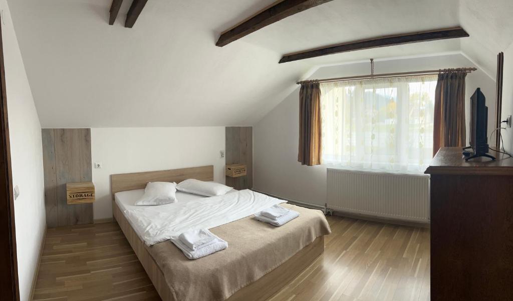 a bedroom with a bed with white sheets and a window at LIKE HOME in Râşnov