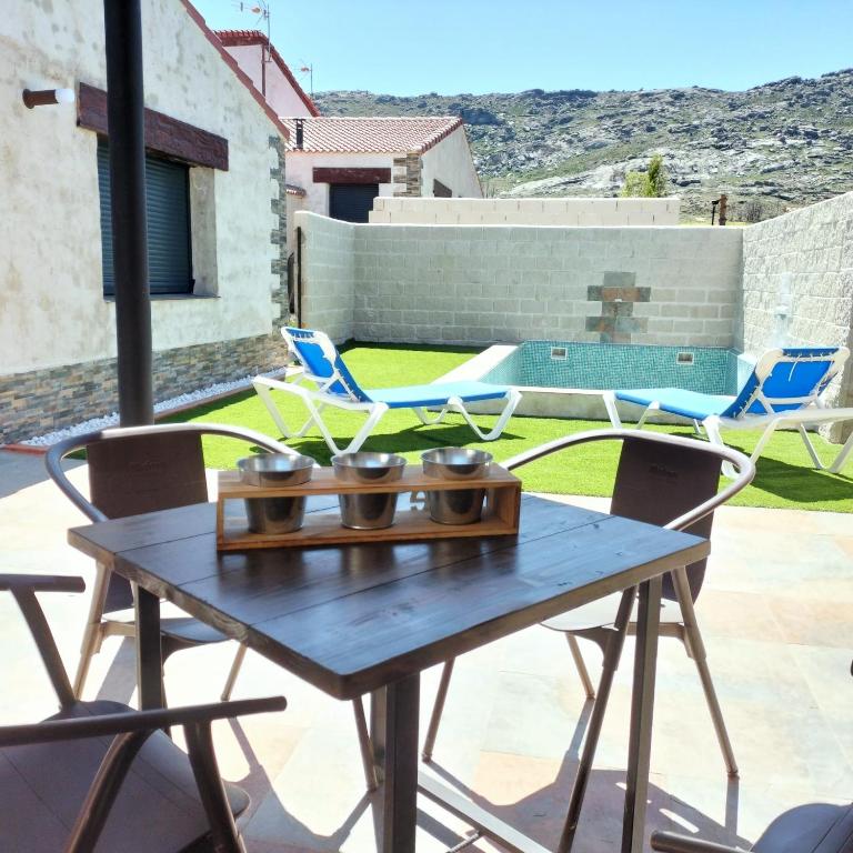a wooden table and chairs on a patio at Villa pose in Robledillo