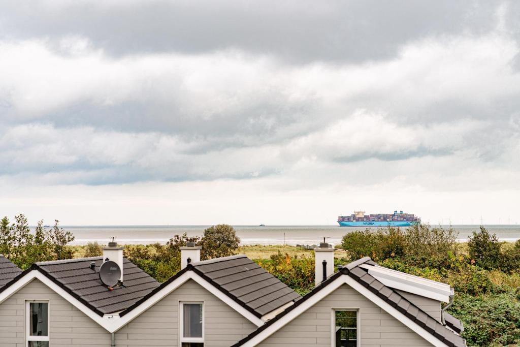 a row of houses with a cruise ship in the ocean at Seaside 49 3 N in Wangerland