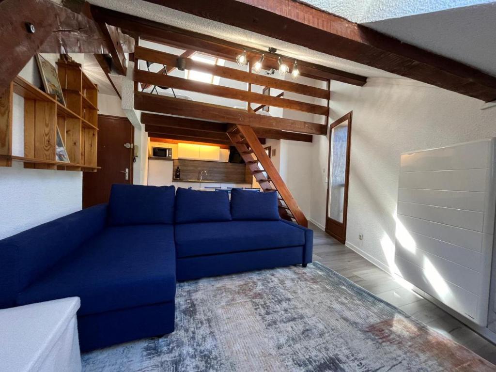 - un salon avec un canapé bleu et un escalier dans l'établissement Haut perché - Duplex familial confortable et rénové bien situé, à Briançon