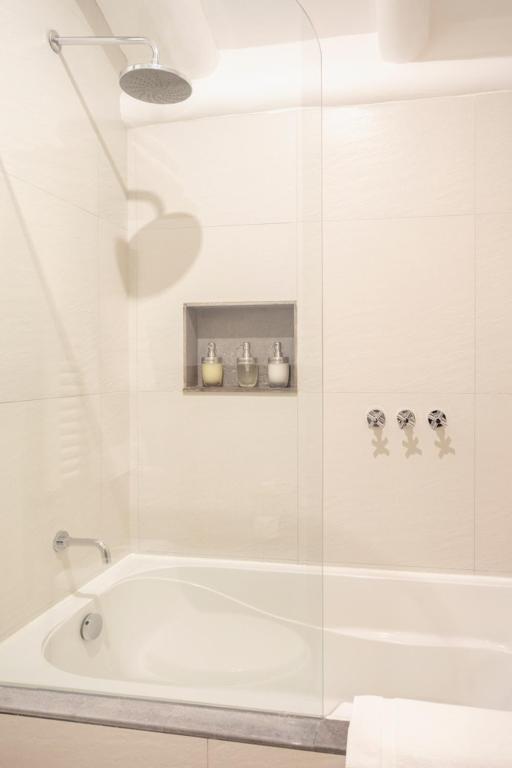 a white bathroom with a tub and a shower at Antigua Casona San Blas in Cusco