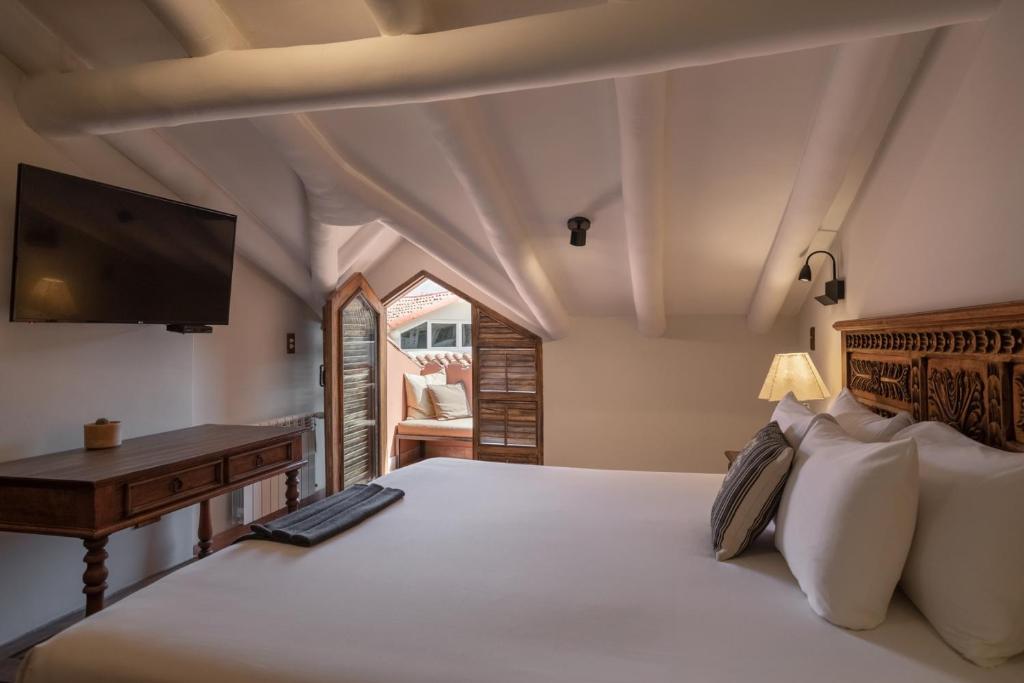 a bedroom with a bed with a flat screen tv at Antigua Casona San Blas in Cusco