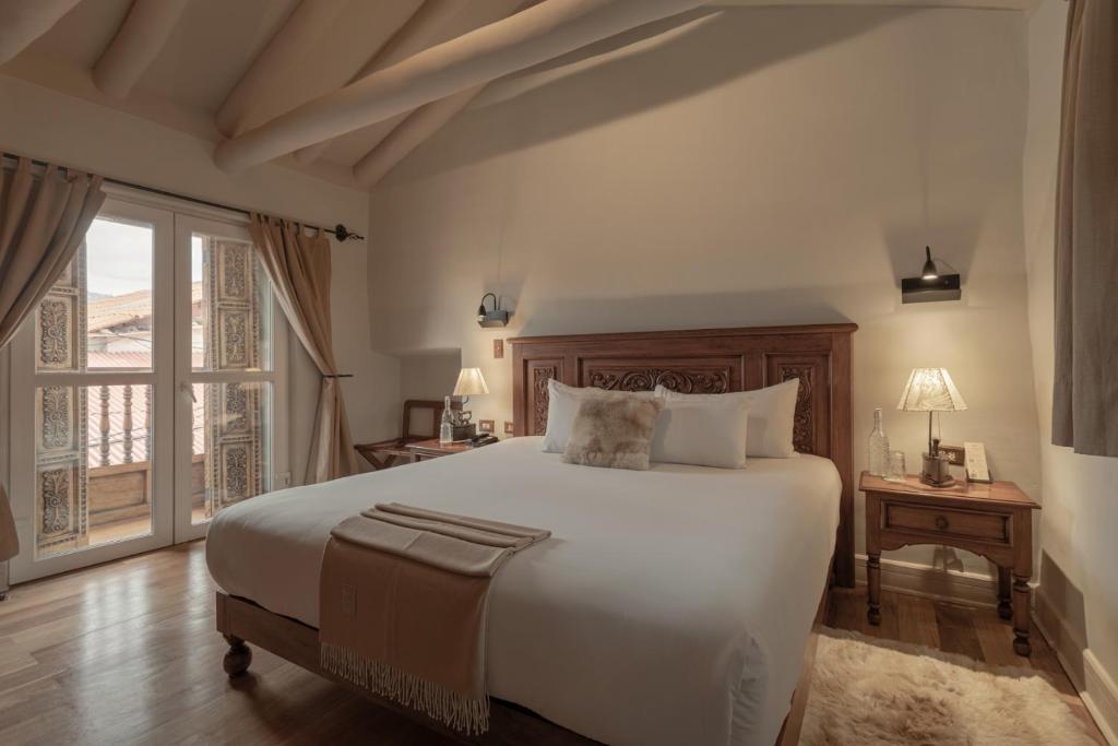 a bedroom with a large white bed and a window at Antigua Casona San Blas in Cusco