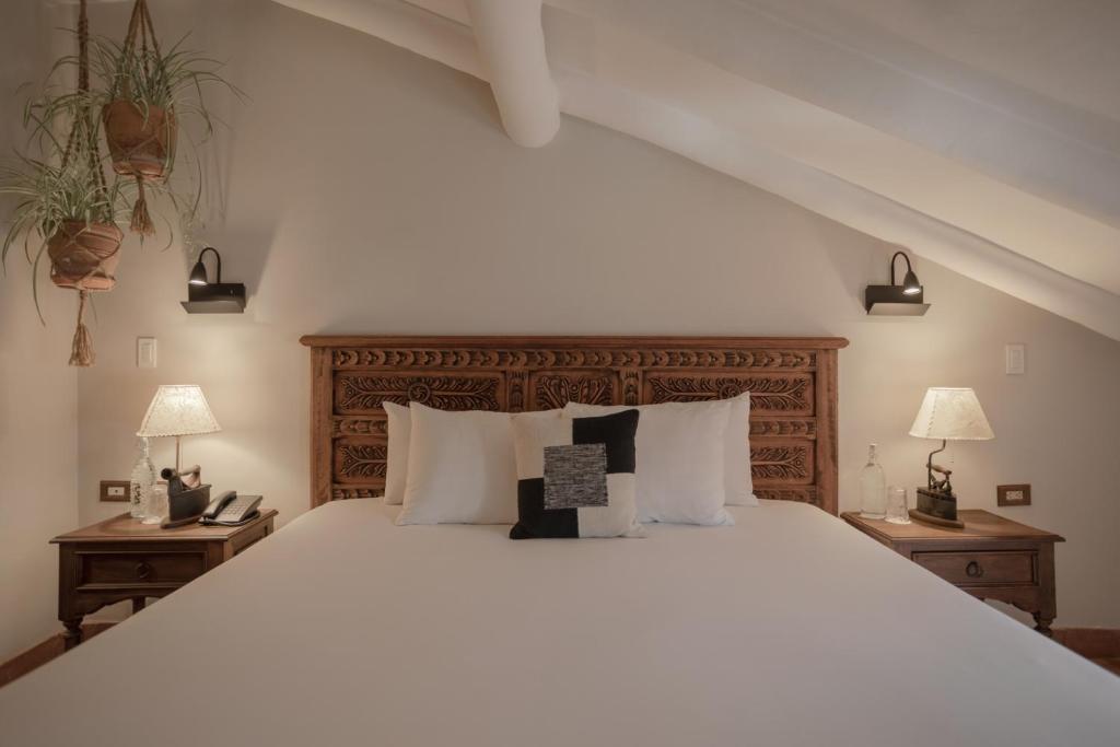 a bedroom with a large white bed with two tables at Antigua Casona San Blas in Cusco