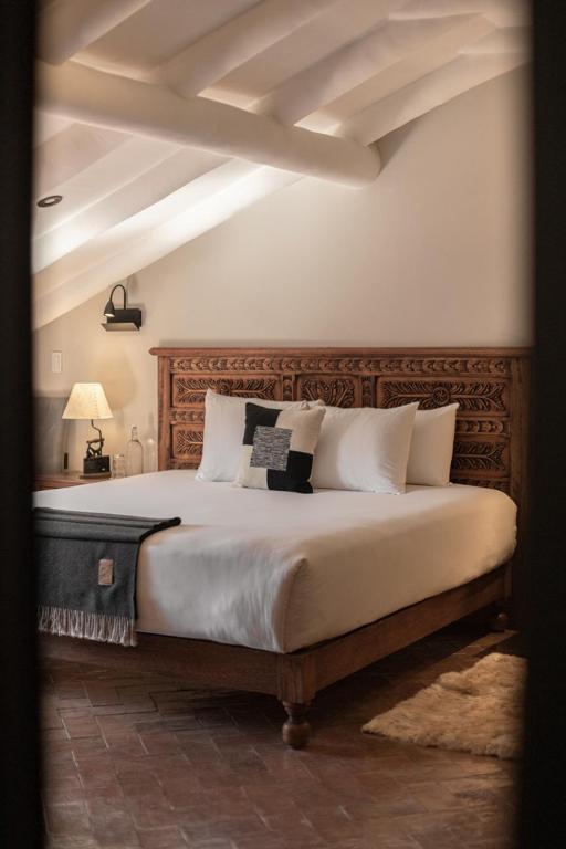 a bedroom with a large bed with a wooden headboard at Antigua Casona San Blas in Cusco