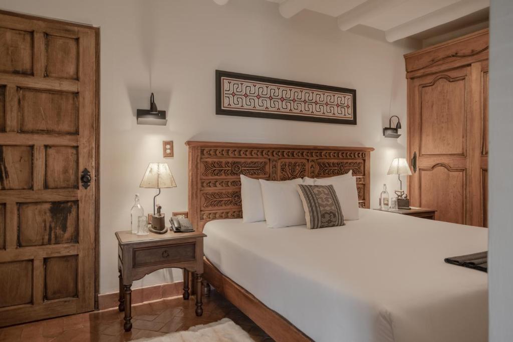 a bedroom with a large white bed and a wooden door at Antigua Casona San Blas in Cusco