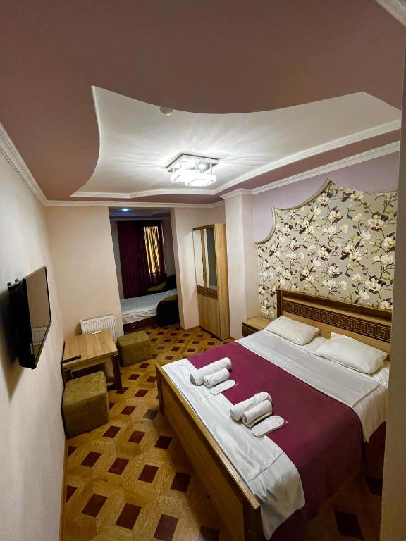 a hotel room with a large bed and a tv at Georgian Palace Hotel in Kutaisi