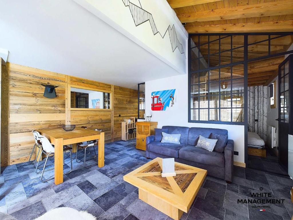 a living room with a couch and a table at Résidence Le Grand Cerf - Appartement fraichement rénové à Courchevel 1550 MAE-3791 in Courchevel