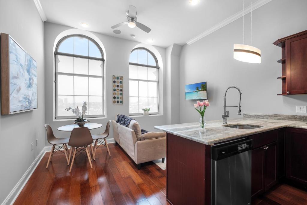 a kitchen and living room with a couch and a table at Stylish 1BR - Rooftop Pool in Philadelphia