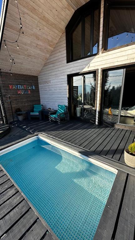 a swimming pool in front of a house at Карпатське Hygge котедж для двох з чаном-джакузі у горах in Slavske