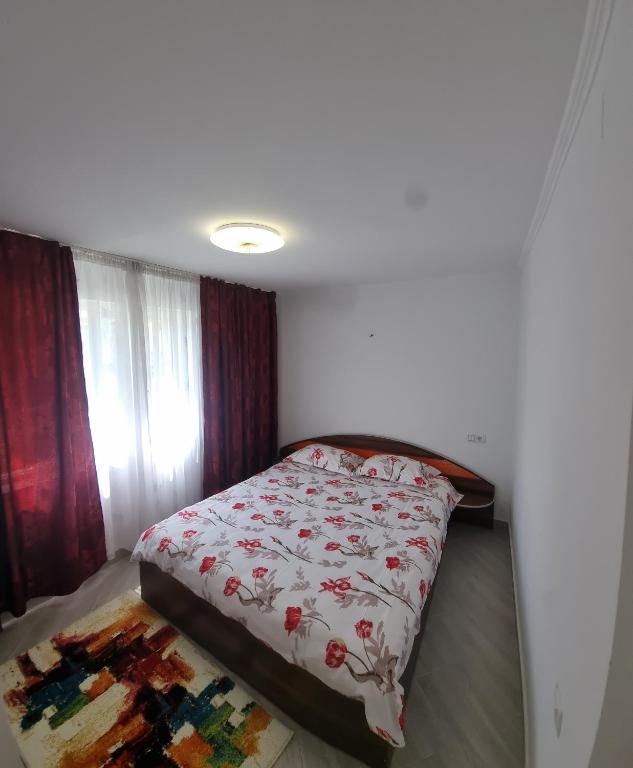 a bedroom with a bed with a floral bedspread at Cavnic Residence 1 in Cavnic