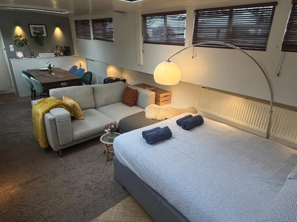 een woonkamer met een bed en een bank bij Woonboot Josja in Amsterdam