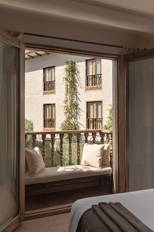 a bedroom with a balcony with a bed and a window at Antigua Casona San Blas in Cusco
