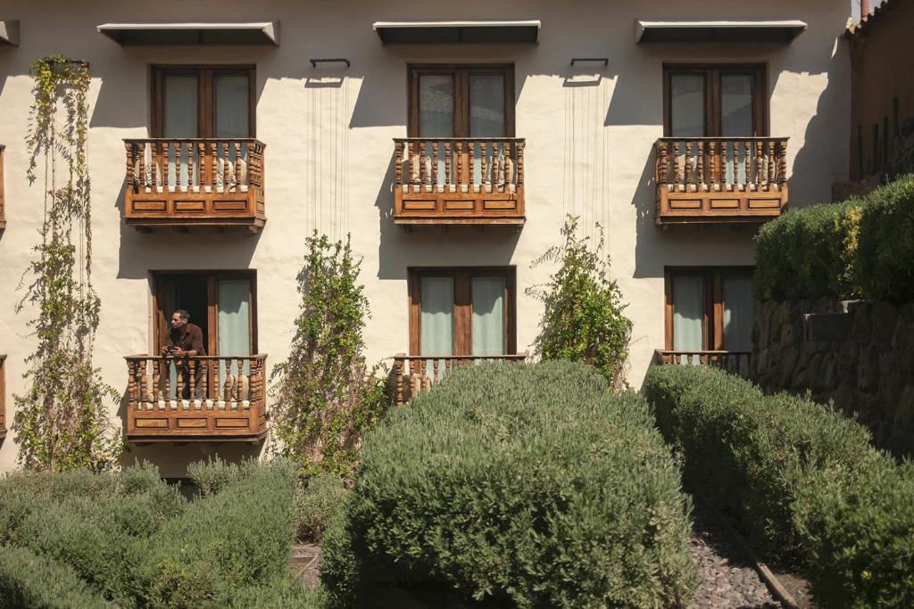 a man standing on a balcony of a building at Antigua Casona San Blas in Cusco