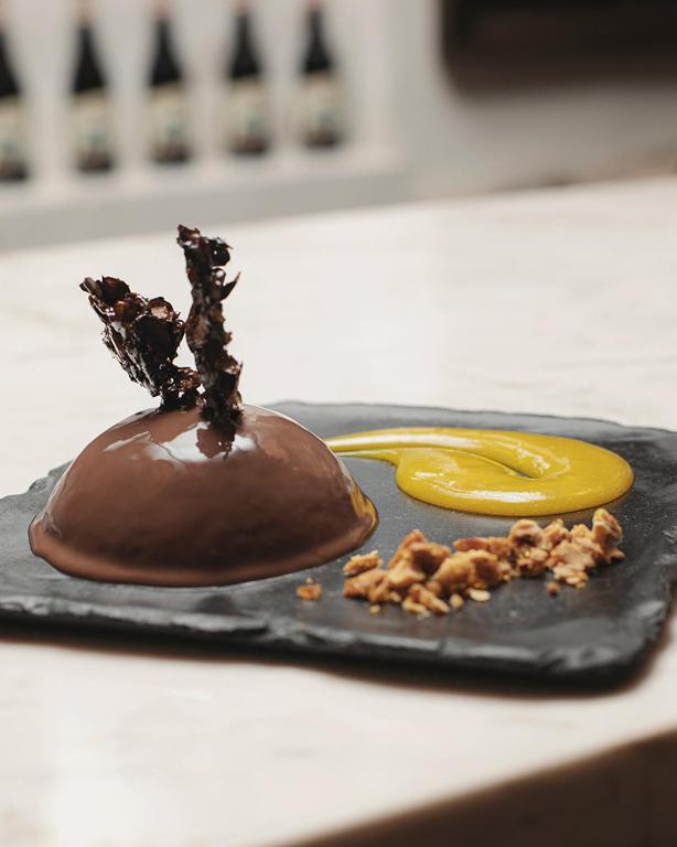 a chocolate dessert on a black plate on a counter at Antigua Casona San Blas in Cusco