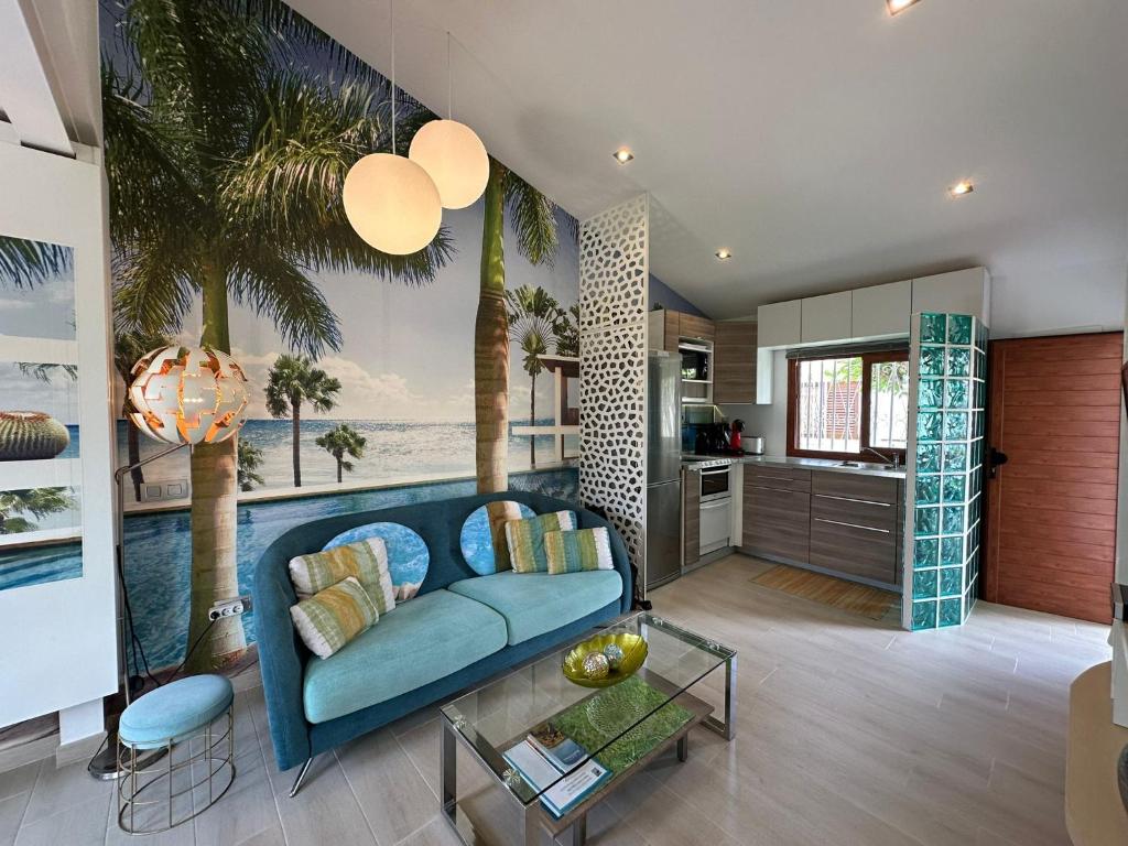 a living room with a blue couch and a kitchen at Parrot Cage - the Gay Villa in Playa del Ingles