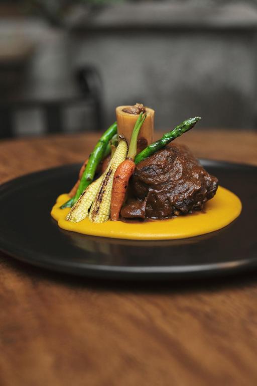 a plate of food with meat and vegetables on a table at Antigua Casona San Blas in Cusco