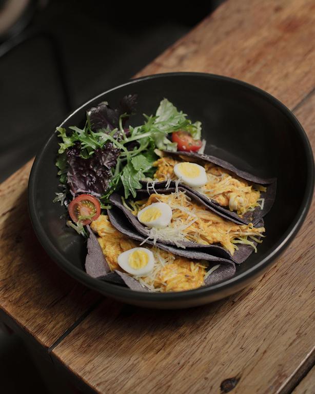 a black plate of food with eggs on a table at Antigua Casona San Blas in Cusco