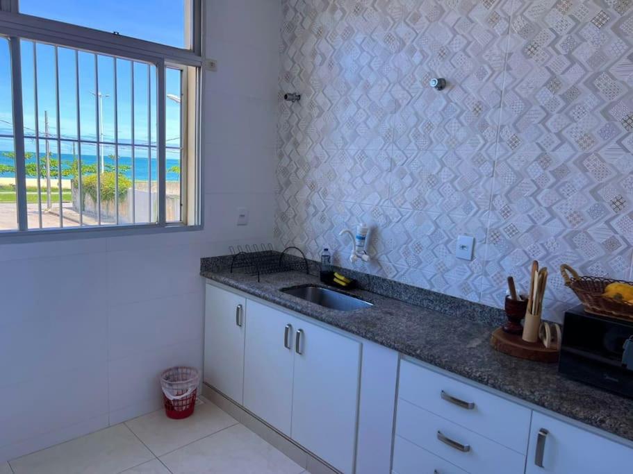 una cucina con lavandino e vista sull'oceano di VISTA PARA MAR - Guarapari ES a Guarapari