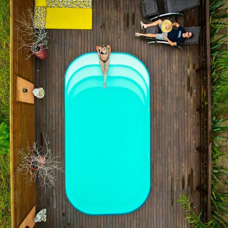 an overhead view of a blue surfboard on a wooden deck at Pousada Rosa Karioka in Praia do Rosa