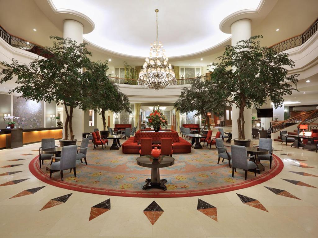 a lobby with a couch and tables and chairs at Aryaduta Manado in Manado