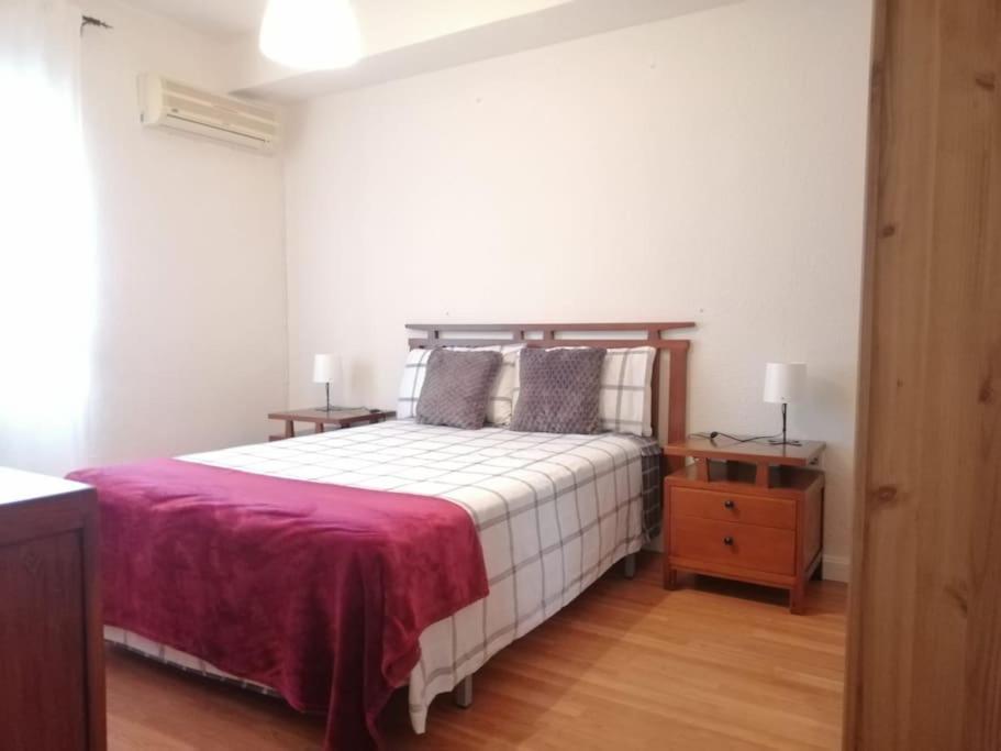 ein Schlafzimmer mit einem großen Bett und zwei Nachttischen in der Unterkunft Apartamento Cortelazor in Huelva