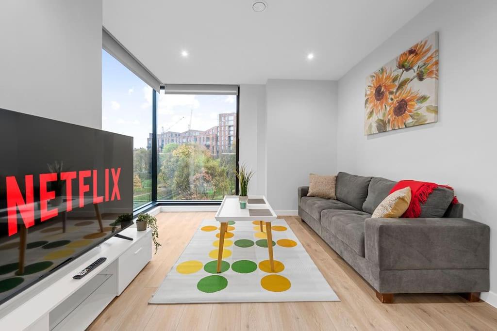 a living room with a couch and a tv at Manchester Haven Chique Modern Apartment in Manchester
