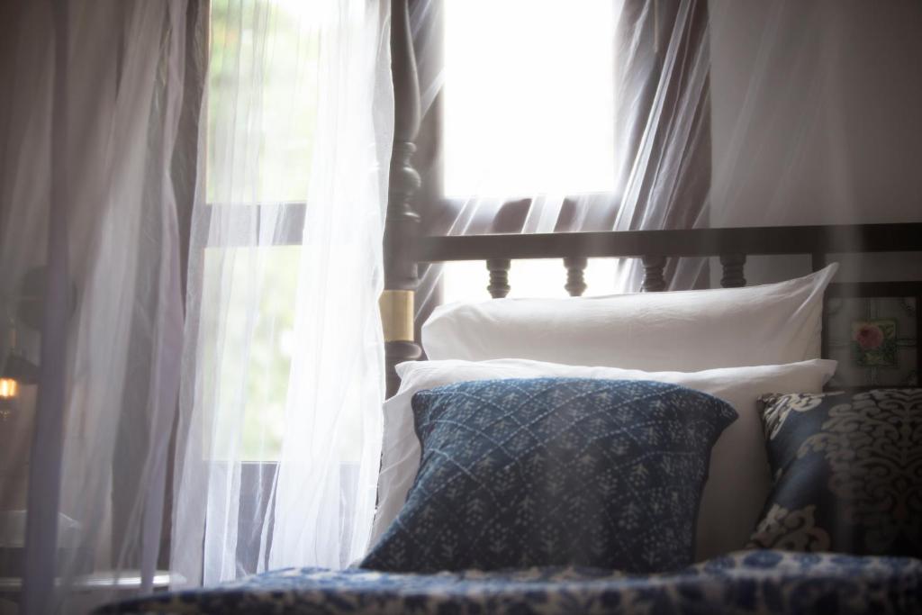a bedroom with a bed with a window at Jawi Peranakan Mansion in George Town