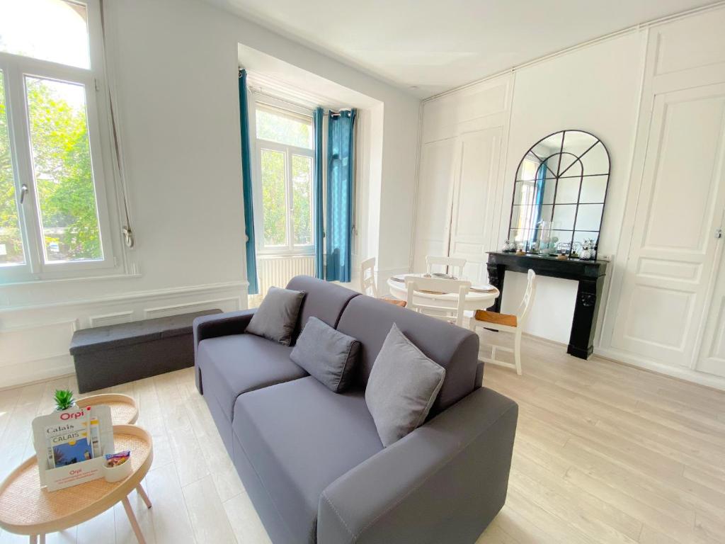 un salon avec un canapé et une table dans l'établissement Le Saint Pierre, à Calais