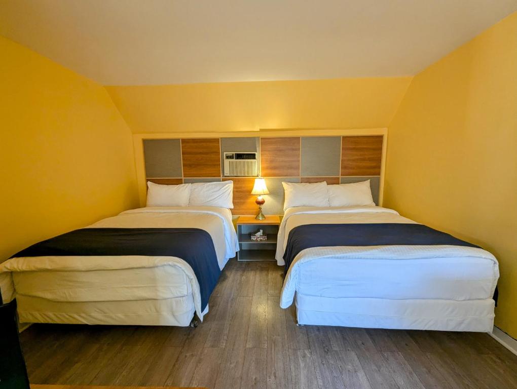 Postel nebo postele na pokoji v ubytování Motel des Pentes et Suites