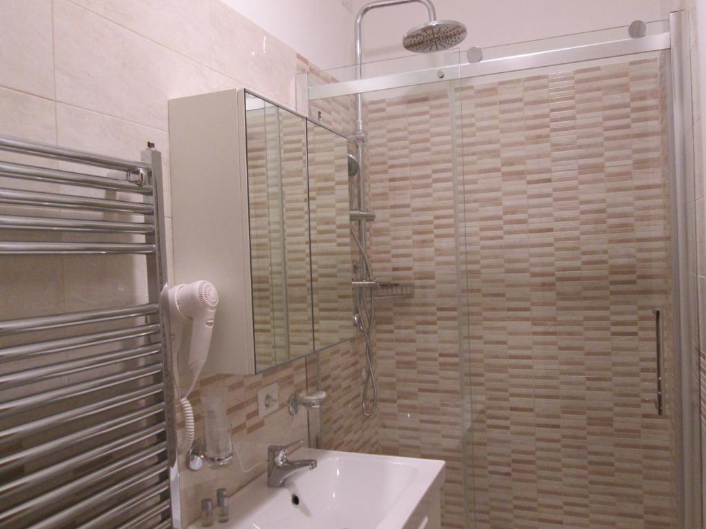y baño con lavabo y ducha con espejo. en Trevi Elegance Suite, en Roma