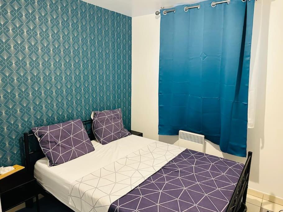 - une petite chambre avec un lit et des oreillers violets dans l'établissement ALEJÒ-HOME, Séjour apaisant!, à La Croix-de-Berny