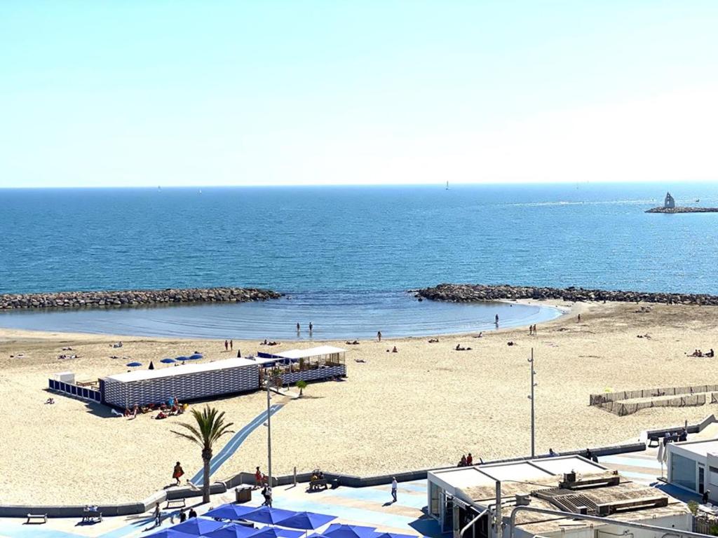 Une plage avec beaucoup de gens dans l'établissement Appartement front de mer 6 pers, parking, WIFI - FR-1-790-32, à La Grande Motte