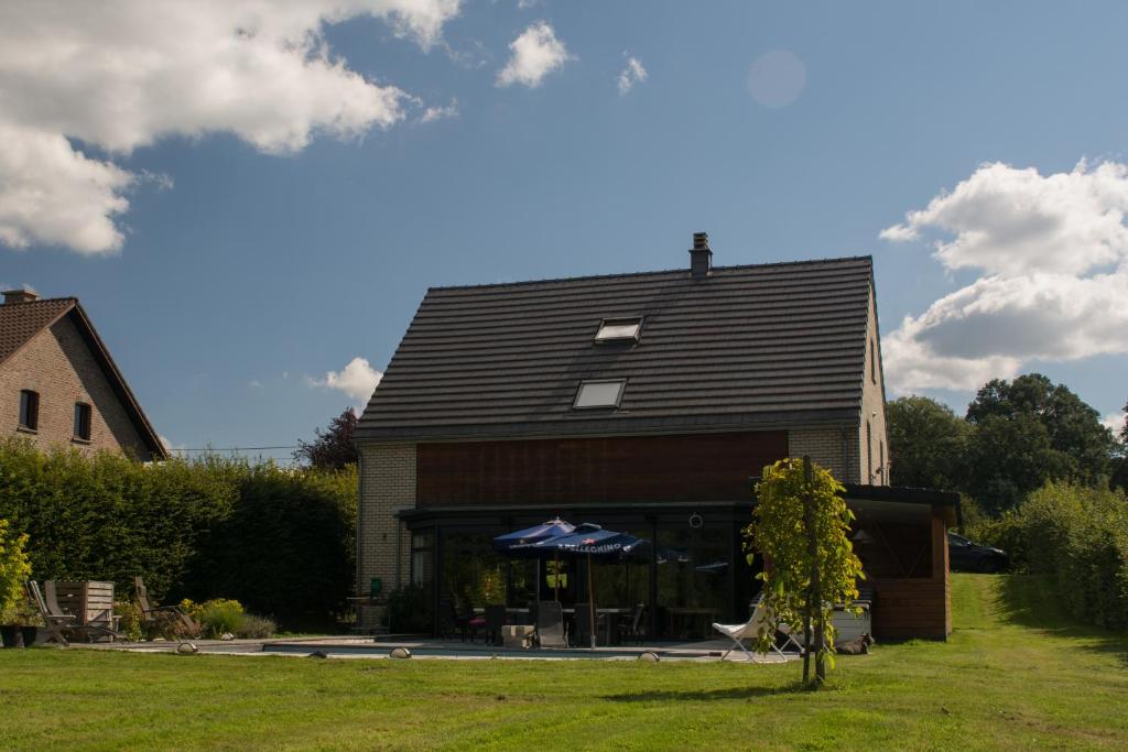 una casa con un techo negro encima en B&B La Raveline en Sart-lez-Spa