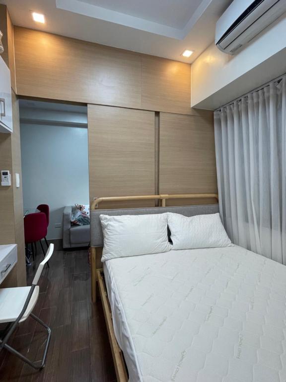 a bedroom with a large bed with a wooden headboard at Beauty Cindrella Home Makati Penthouse 3 Bedroom in Manila