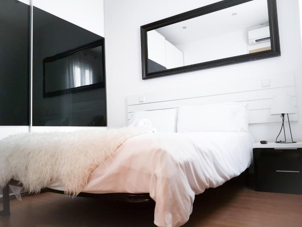 A bed or beds in a room at Apartamentos Day Madrid ILDEFONSO Centro Gran Via Sol Malasaña